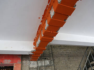 Placa de acero adherida y anclaje instalado en postes para reforzar columnas y vigas