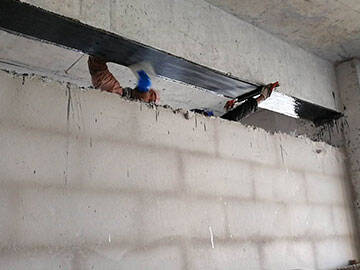 Reparación de grietas en estructuras de hormigón mediante tejido de fibra de carbono.